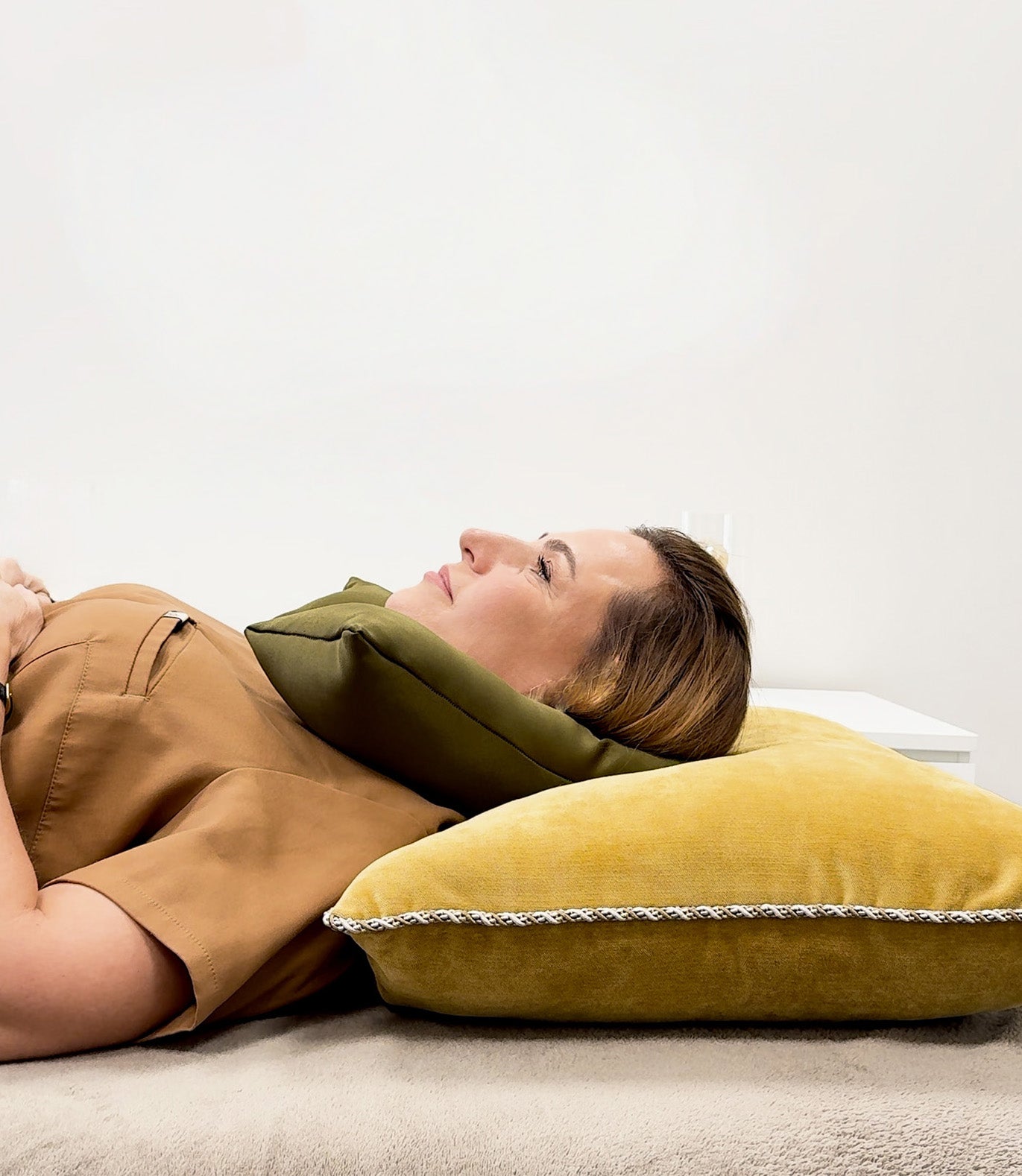 Moteris guli su kaklo atrama – atpalaiduoti pečiai, neutrali laikysena